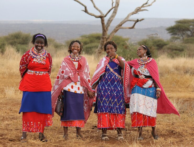 a group of women standing next to each other in a field