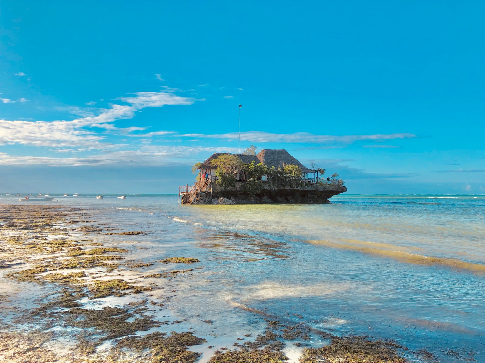 brown rock formation on sea under blue sky during daytime